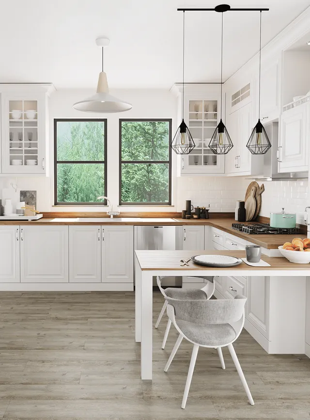 Modern white kitchen with wooden countertops, gray flooring, two windows, and hanging pendant lights over a small table.